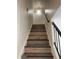 Well-lit staircase with wooden steps and black metal railing against a white brick wall at 4714 E Broadway Rd, Phoenix, AZ 85040