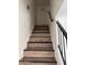 Indoor stairs with wood-look laminate and black railing at 4714 E Broadway Rd, Phoenix, AZ 85040