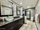 Modern bathroom featuring dual glass vessel sinks, black cabinets, and stylish fixtures at 511 E Port Au Prince Ln, Phoenix, AZ 85022