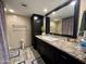 Bathroom featuring a granite countertop, dark cabinetry, and a decorative mirror at 511 E Port Au Prince Ln, Phoenix, AZ 85022