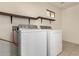 Laundry room with washer, dryer, and wooden shelves at 5315 W Christy Dr, Glendale, AZ 85304