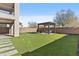 Lush backyard featuring green grass, a pergola with a swing, and a stepping stone pathway at 55 N Abalone Ct, Gilbert, AZ 85233