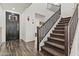 Bright foyer with a dark wood door and a staircase with carpet and dark wood railing at 55 N Abalone Ct, Gilbert, AZ 85233