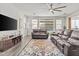 Cozy living room with tile floors, leather furniture, and a view of the backyard at 55 N Abalone Ct, Gilbert, AZ 85233