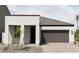 White exterior of a single-story home with a two-car garage and landscaping at 5630 S Daisy Patch Pl, Phoenix, AZ 85040