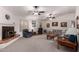 Living room featuring a fireplace, ceiling fans, and couches at 6258 E Ivy St, Mesa, AZ 85205