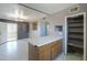 A galley kitchen with wood cabinets, an island, and a pantry at 6649 W Orange Dr, Glendale, AZ 85301