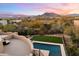 Aerial view of a luxury home with a pool and desert landscaping, mountain views at sunset at 6708 E Calle De Las Estrellas Rd, Cave Creek, AZ 85331