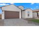 White house with brown garage door and a well-manicured lawn at 699 E Greenback Dr, San Tan Valley, AZ 85140