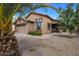 Tan house with a two-car garage, palm trees, and well-maintained landscaping at 9036 E Halifax Cir, Mesa, AZ 85207