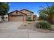 One-story house with tan exterior, two-car garage, and landscaped front yard at 9036 E Halifax Cir, Mesa, AZ 85207