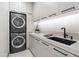 Bright laundry room with stacked washer and dryer and modern sink at 9280 E Thompson Peak Pkwy # 15, Scottsdale, AZ 85255