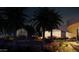 Night view of the home's front yard, featuring palm trees and luxury vehicles at 9428 E Pinnacle Vista Dr, Scottsdale, AZ 85255