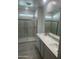 Modern bathroom with double vanity, walk-in shower, and marble tile at 9514 N 178Th Dr, Waddell, AZ 85355