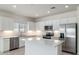 Modern kitchen with white cabinets, stainless steel appliances, and a large island at 9514 N 178Th Dr, Waddell, AZ 85355