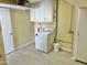 Bright laundry room featuring a modern dryer, tile flooring, and overhead shelving for storage at 9746 N 105Th Dr, Sun City, AZ 85351