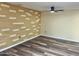 Well-lit room featuring hard wood floors and a decorative wall with an installed ceiling fan at 9746 N 105Th Dr, Sun City, AZ 85351