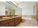 Bathroom with double vanity, granite countertop, and large soaking tub at 9926 E Hidden Green Dr, Scottsdale, AZ 85262