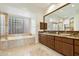 Elegant bathroom with double sinks, granite countertop, and a large soaking tub at 9926 E Hidden Green Dr, Scottsdale, AZ 85262