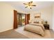 Cozy bedroom featuring a ceiling fan, neutral tones, and sliding doors to the outdoor area at 9926 E Hidden Green Dr, Scottsdale, AZ 85262