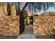 Stone wall entry gate opens to a private courtyard with fountain at 9926 E Hidden Green Dr, Scottsdale, AZ 85262