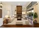 Inviting living room with a stone fireplace, built-in shelves, and sliding glass doors to the outdoors at 9926 E Hidden Green Dr, Scottsdale, AZ 85262