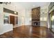 Bright living room with hardwood floors, stone fireplace, and access to backyard at 9926 E Hidden Green Dr, Scottsdale, AZ 85262