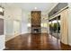 Spacious living room featuring hardwood floors, a large stone fireplace, and sliding glass doors at 9926 E Hidden Green Dr, Scottsdale, AZ 85262