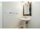 Elegant powder room with pedestal sink, mirror, and towel bar at 9926 E Hidden Green Dr, Scottsdale, AZ 85262