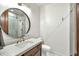 Modern bathroom featuring a round mirror, a vanity with granite countertop and a walk-in shower at 10040 E Happy Valley Rd # 297, Scottsdale, AZ 85255