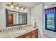 Bathroom featuring granite counters, a decorative mirror, and a glass shower with decorative tile at 10040 E Happy Valley Rd # 297, Scottsdale, AZ 85255