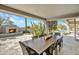 Covered patio featuring a long dining table, desert landscaping and an outdoor fireplace overlooking the pool at 10040 E Happy Valley Rd # 297, Scottsdale, AZ 85255