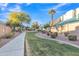 Concrete pathway winds through a grassy community area with trees and shrubs at 1015 S Val Vista Dr # 87, Mesa, AZ 85204