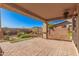 Covered back patio boasts brick pavers and a well maintained desert landscaped yard with block wall at 12815 W Milton Dr, Peoria, AZ 85383