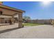 A covered patio with stone flooring overlooks the backyard with gravel and grass at 12815 W Milton Dr, Peoria, AZ 85383