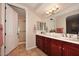 Double vanity bathroom with dark wood cabinets and a large mirror at 13450 E Via Linda -- # 1010, Scottsdale, AZ 85259