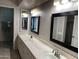Bright bathroom featuring dual sinks, framed mirrors, white cabinets, and recessed lighting at 136 E Boca Raton Rd, Phoenix, AZ 85022