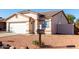 House exterior with a white garage door and desert landscaping at 16008 N Hollyhock St, Surprise, AZ 85378