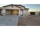 Single-story house with an attached garage and open driveway at 16008 N Hollyhock St, Surprise, AZ 85378