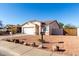 House exterior with a white garage door and desert landscaping at 16008 N Hollyhock St, Surprise, AZ 85378