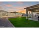 Backyard featuring a manicured lawn, block fence, and covered patio at 16790 W Molly Ln, Surprise, AZ 85387