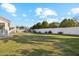 Large grassy backyard bordered by mature trees and a white privacy wall at 1743 E Menlo St, Mesa, AZ 85203