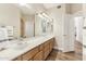 Bathroom with double sinks, wood cabinets, and a large mirror at 1743 E Menlo St, Mesa, AZ 85203