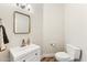 Elegant half bathroom with a modern sink, sleek faucet, gold mirror and a toilet at 1743 E Menlo St, Mesa, AZ 85203