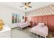 Charming bedroom featuring twin beds with decorative floral wallpaper and paneled accent wall at 1743 E Menlo St, Mesa, AZ 85203