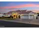 Beautiful home exterior at sunset, featuring a three-car garage and manicured landscaping at 1743 E Menlo St, Mesa, AZ 85203