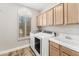 Efficient laundry room with appliances, storage cabinets, utility sink, and natural light at 1743 E Menlo St, Mesa, AZ 85203