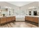 Spa-like main bathroom boasts a soaking tub, dual vanities, and wood look floors at 1743 E Menlo St, Mesa, AZ 85203