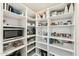 Walk-in pantry features organized white shelving filled with food items and a microwave for convenience at 1743 E Menlo St, Mesa, AZ 85203