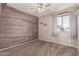 Bedroom with wood-like accent wall and carpet at 17774 W Watson Ln, Surprise, AZ 85388